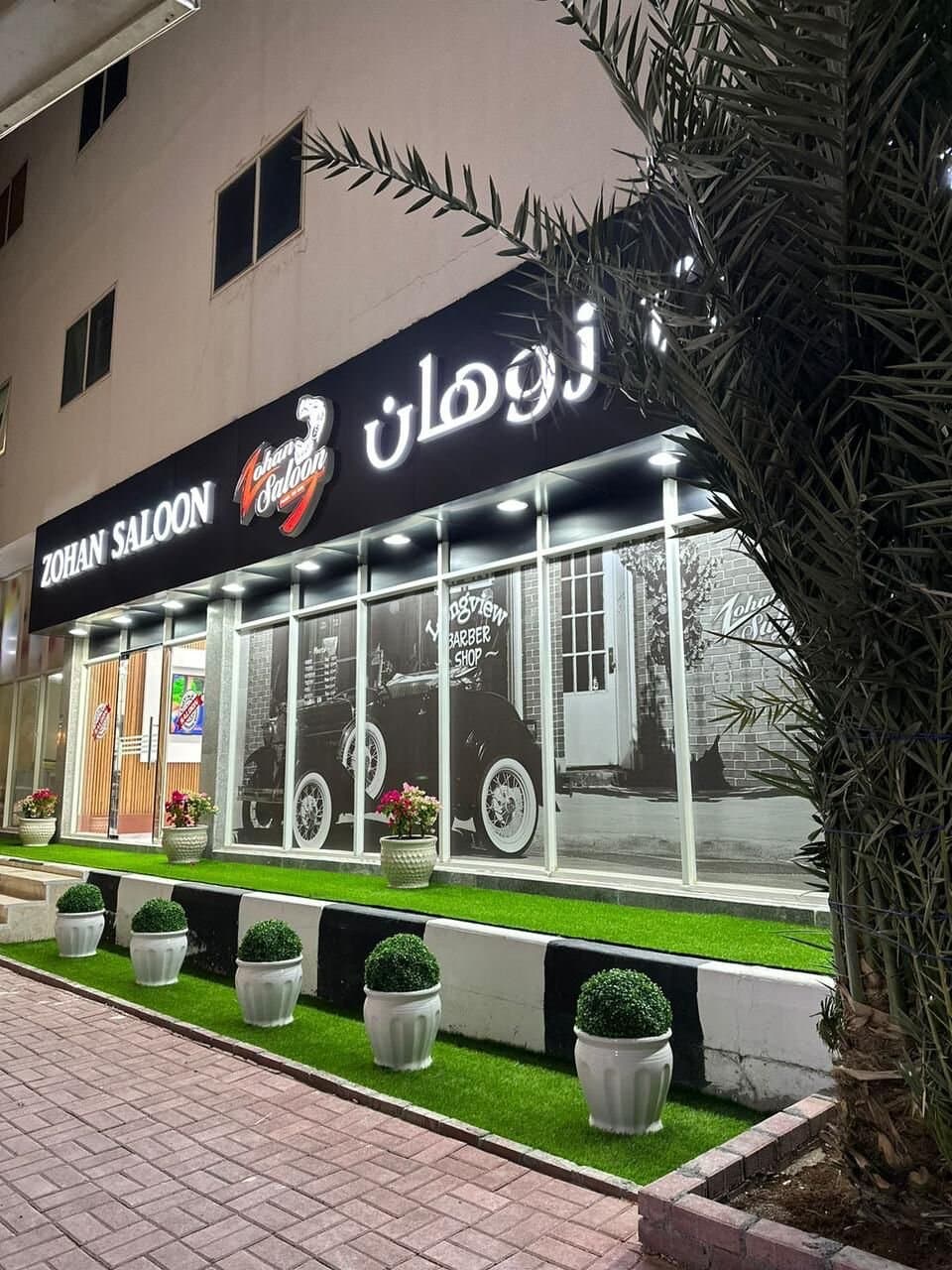 Zohan Saloon storefront at night in Masafi, Fujairah, with vintage car mural