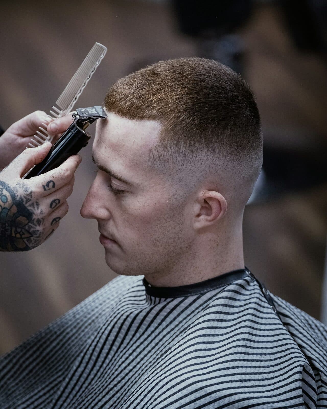 Close crop of a barber trimming a client's fade